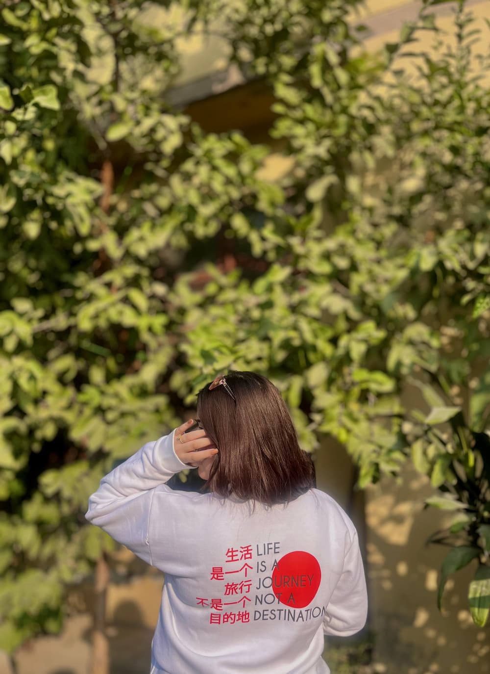 White custom-designed sweatshirt with red text and heart graphic, featuring an inspirational quote in English and Chinese. Stylish and cozy apparel for a unique look.